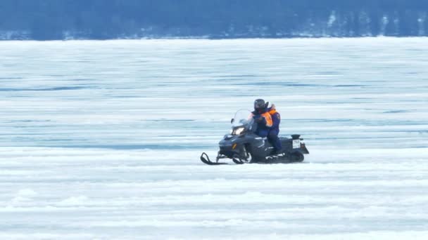 Hombre montando moto de nieve en el hielo del lago Onego, Karelia, Rusia — Vídeo de stock