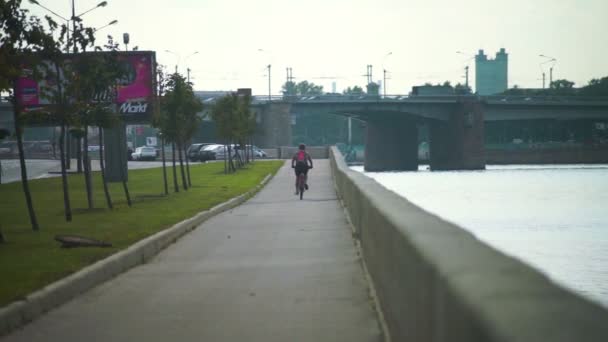 Cyklista, pohybující se po nábřeží řeky Něvy — Stock video