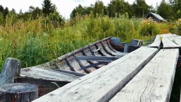 Obsolete woden vessel boat neas pier at lake shore — Stock Video