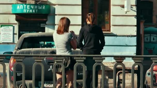 Две девушки разговаривают взглядом со спины — стоковое видео