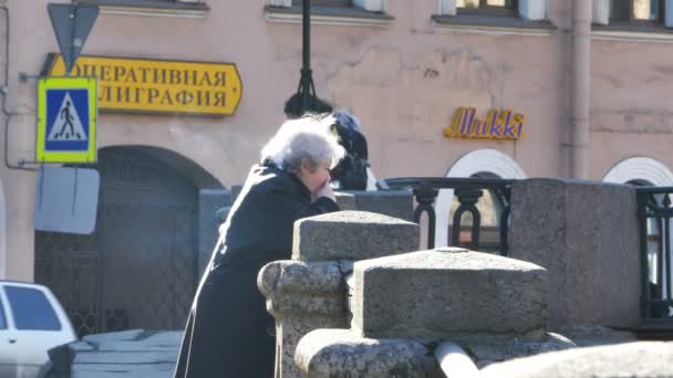 Staruszka palenia na nabrzeże rzeki w Sankt Petersburg, Federacja Rosyjska — Wideo stockowe