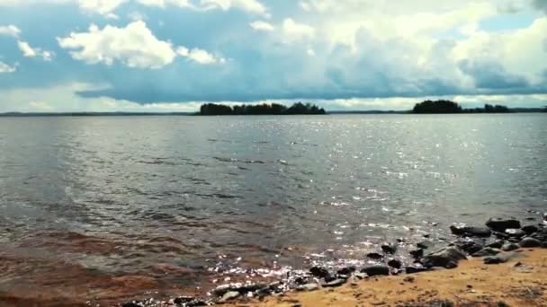 Water spatten de stenen op de oever van het meer — Stockvideo