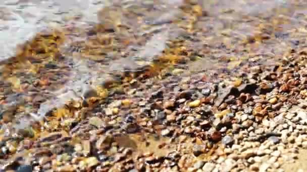 Salpicaduras de agua a las piedras en la orilla del lago — Vídeos de Stock