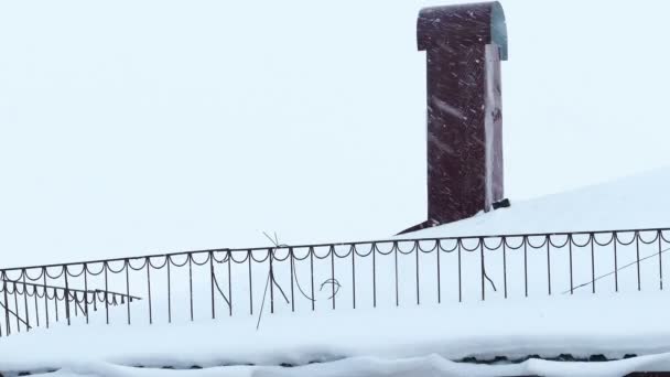 Schornstein auf einem schneebedeckten Hausdach am Wintertag — Stockvideo