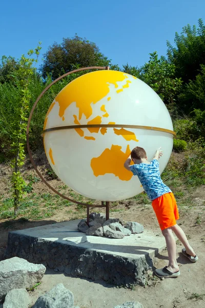 Chłopiec Stara Się Obracać Ziemię Formie Kuli Ziemskiej Azja Oceania — Zdjęcie stockowe