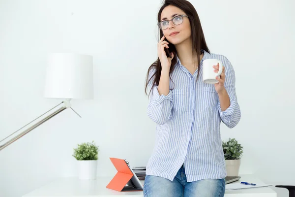 Jeune femme d'affaires utilisant son téléphone portable au bureau . — Photo