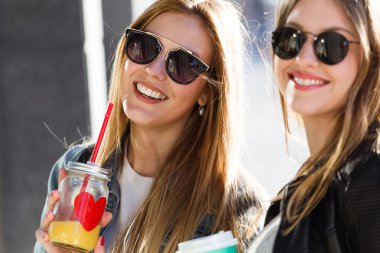 Güzel genç kadın konuşmak ve şehirde gülüyor.