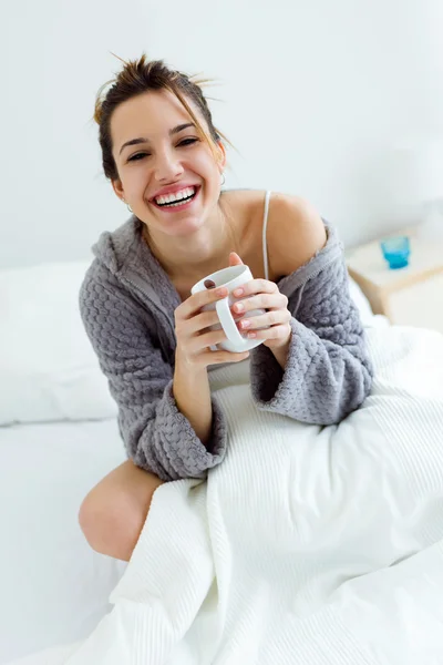 Hermosa joven bebiendo café en la cama . — Foto de Stock