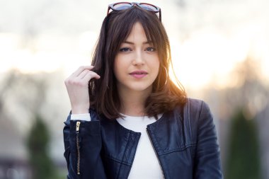 Güzel genç kadın sokakta kamera bakıyor.