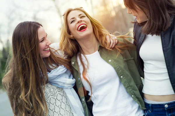 Tres mujeres jóvenes hablando y riendo en la calle . —  Fotos de Stock