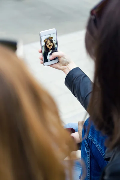 Mooie jonge vrouw met behulp van haar mobiele telefoon in de straat. — Stockfoto