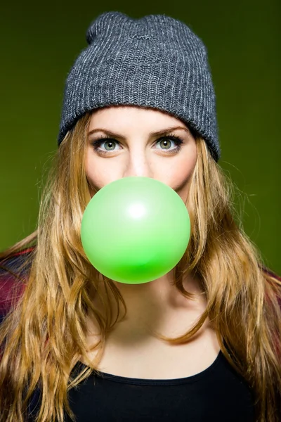 Hermosa joven que sopla chicle verde. Aislado . —  Fotos de Stock