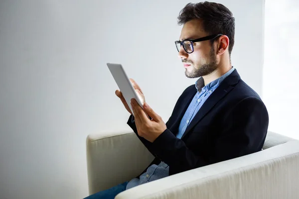 Knappe jonge man aan het werk met digitale tablet in het kantoor. — Stockfoto