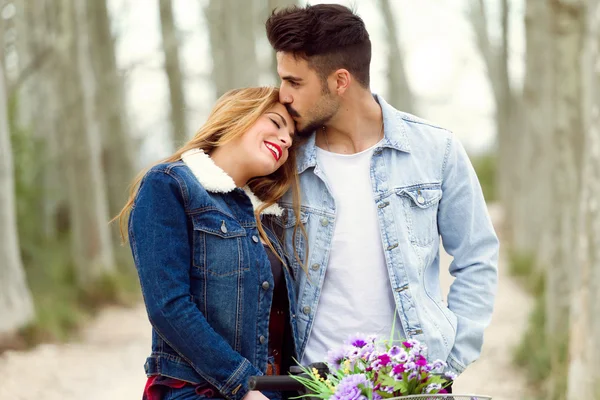 Hermosa pareja joven enamorada en bicicleta en el parque . — Foto de Stock