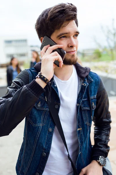 Knappe student gebruik mobiele telefoon in de straat. — Stockfoto