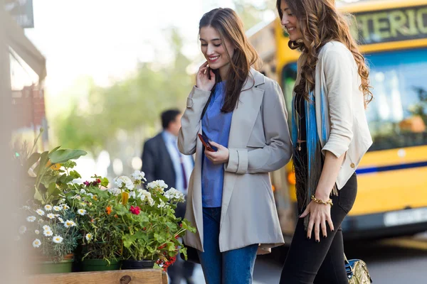 Dos hermosas mujeres jóvenes caminando y hablando en la calle . —  Fotos de Stock