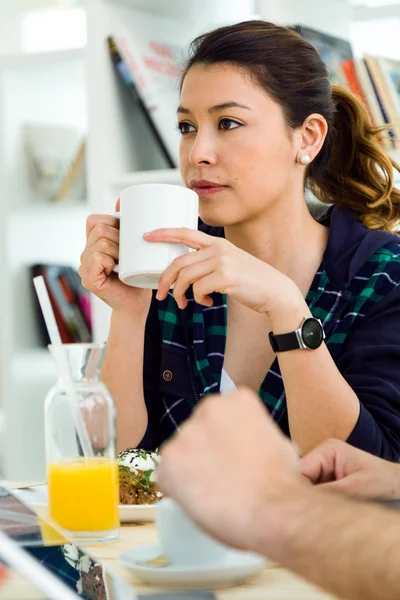 Vacker ung kvinna njuter av frukost i köket. — Stockfoto