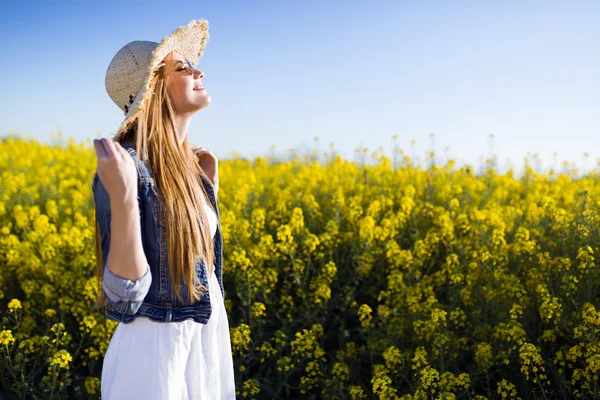 Hermosa joven disfrutando de la primavera en un campo . —  Fotos de Stock