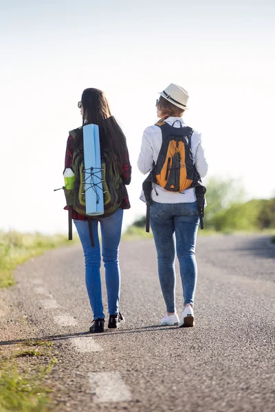 Two beautiful ladies hikers walking on the road. — Stock Photo, Image