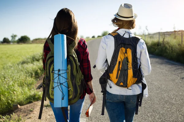 Two beautiful ladies hikers walking on the road. — Stock Photo, Image