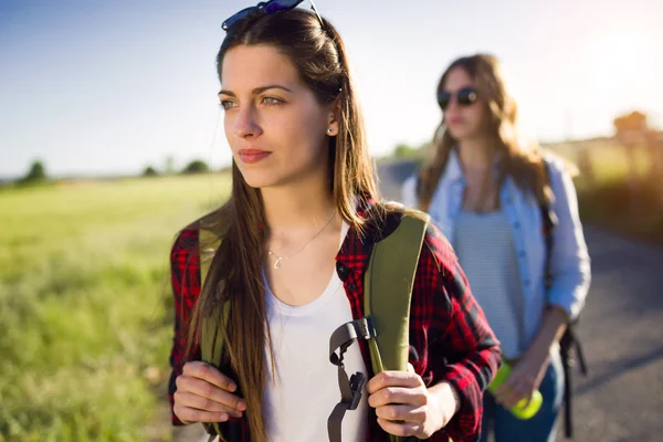 Two beautiful ladies hikers walking on the road. — Stock Photo, Image