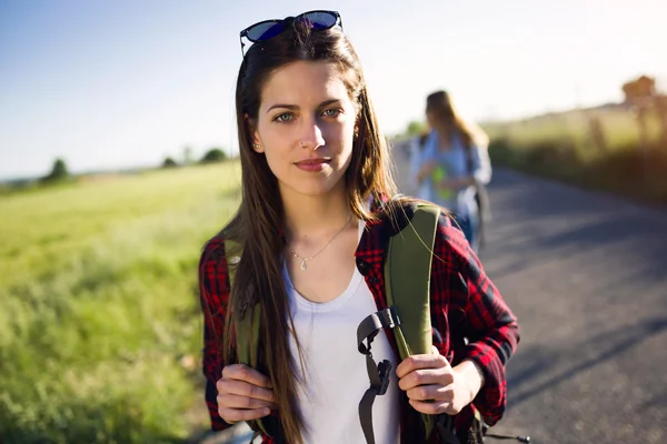 Beautiful young woman hiker walking on the road. — Stock Photo, Image