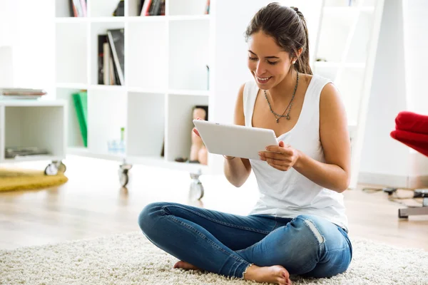 Vacker ung kvinna med sin digitala tablett hemma. — Stockfoto