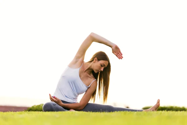 Schöne junge Frau macht Yoga auf der Straße. — Stockfoto