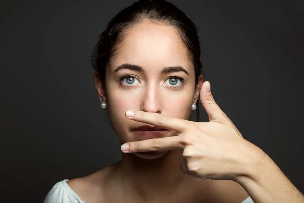 Schöne junge Frau, die ihren Mund mit der Hand bedeckt. isoliert. — Stockfoto