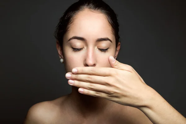 Beautiful young woman covering her mouth with hand. Isolated. — Stock Photo, Image