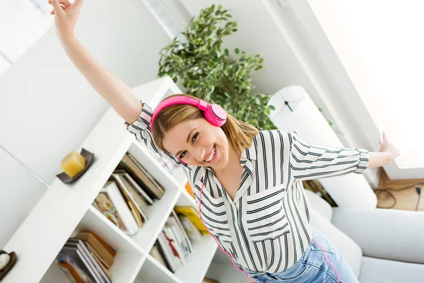 Schöne junge Frau hört zu Hause Musik. — Stockfoto