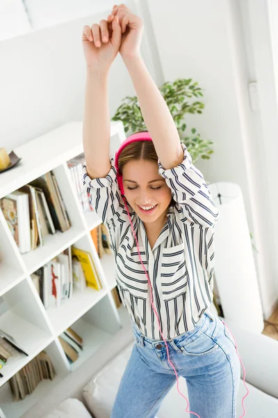 Schöne junge Frau hört zu Hause Musik. — Stockfoto