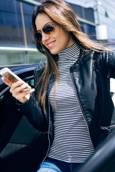 Mulher bonita usando seu telefone celular no carro . — Fotografia de Stock