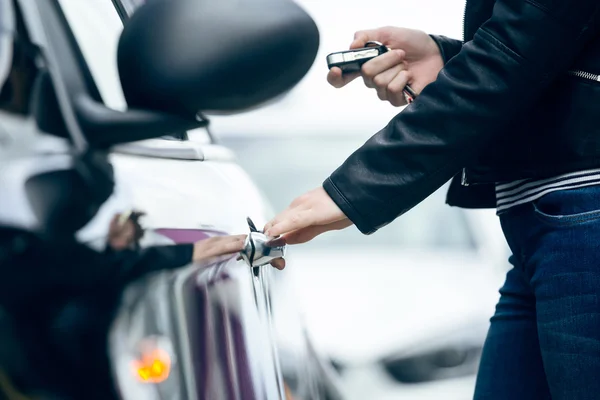 Krásná mladá žena otevření její auto. — Stock fotografie