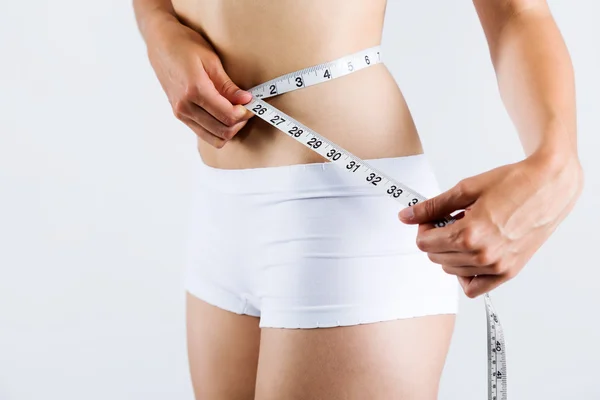 Mulher medindo seu corpo magro. isolado em fundo branco . — Fotografia de Stock