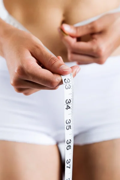 Mujer midiendo su delgado cuerpo. aislado sobre fondo blanco . — Foto de Stock