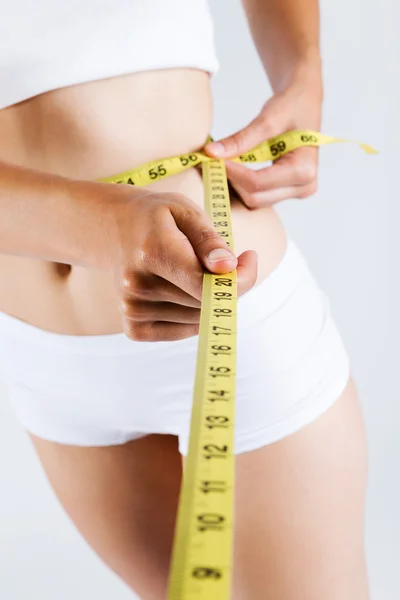 Woman measuring her slim body. Isolated on white background. — Stock Photo, Image