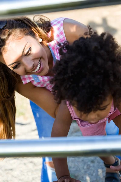 Bela jovem mãe com seu filho se divertindo no parque . — Fotografia de Stock