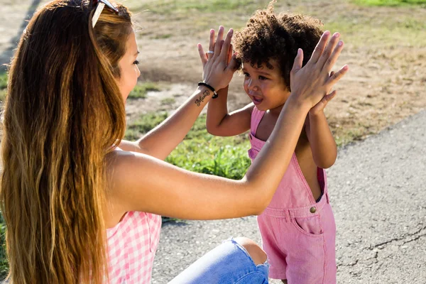 Bela jovem mãe com seu filho se divertindo no parque . — Fotografia de Stock