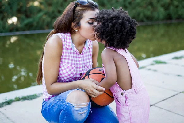 Красивая молодая мать целует своего сына в парке . — стоковое фото