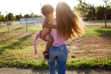 Güzel genç anne oğluyla parkta eğleniyor.