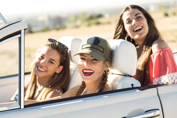 Three pretty young women driving on road trip on beautiful summe — Stock Photo, Image