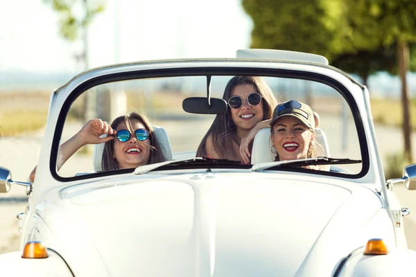 Three pretty young women driving on road trip on beautiful summe — Stock Photo, Image