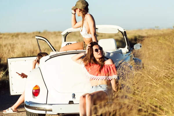 Trois jolies jeunes femmes au volant en road trip sur une belle summe — Photo