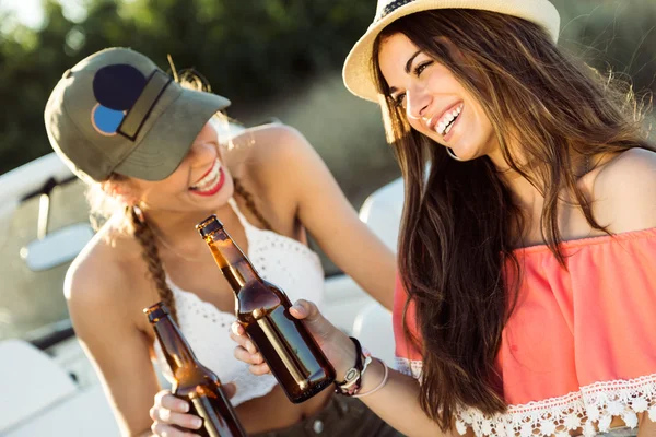 Vackra unga kvinnor dricker öl och njuta av sommardag. — Stockfoto