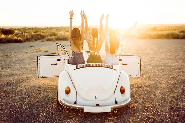 Three pretty young women driving on road trip on beautiful summe — Stock Photo, Image