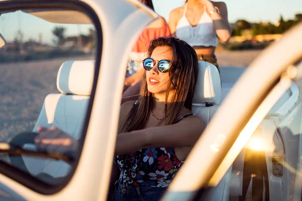 Three pretty young women driving on road trip on beautiful summe — Stock Photo, Image