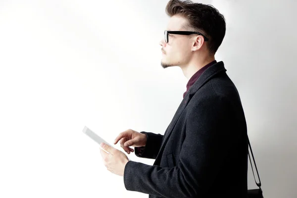 Knappe jongeman met behulp van zijn digitale tablet. Geïsoleerd op wit. — Stockfoto