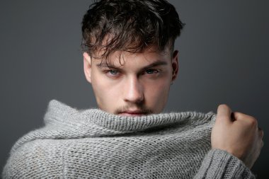 Kameraya bakarak yakışıklı delikanlı. Gri izole.