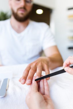 Salonda manikür yapan genç erkek. Güzellik kavramı.